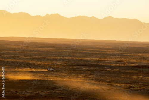 Suvs drive across the vast gobi desert in the early morning hours.