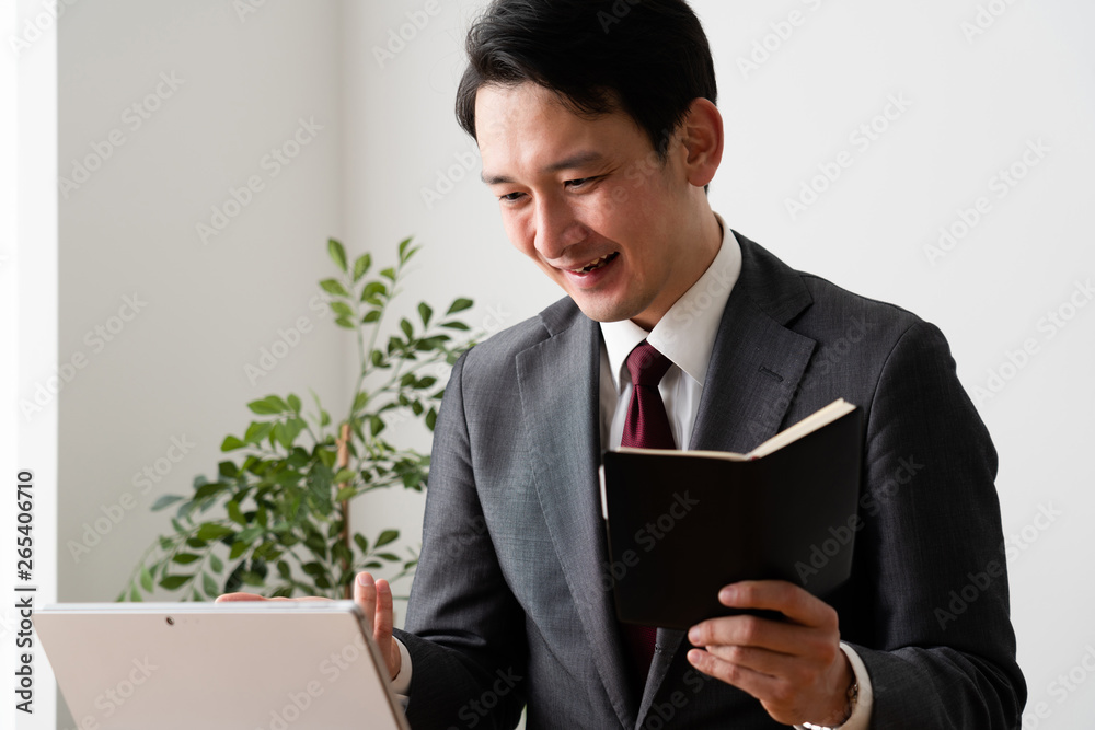 ビデオ会議をするスーツの男 ビデオ会議をするスーツの男
