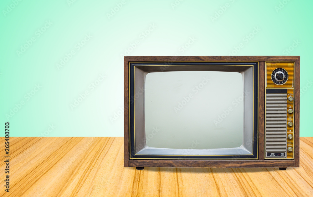 Retro old television receiver on table front gradient green wall background.vintage tv with cut screen on perspective wooden floor.. Retro old television receiver on table front gradient green wall background.vintage tv with cut screen on perspective wooden floor..
