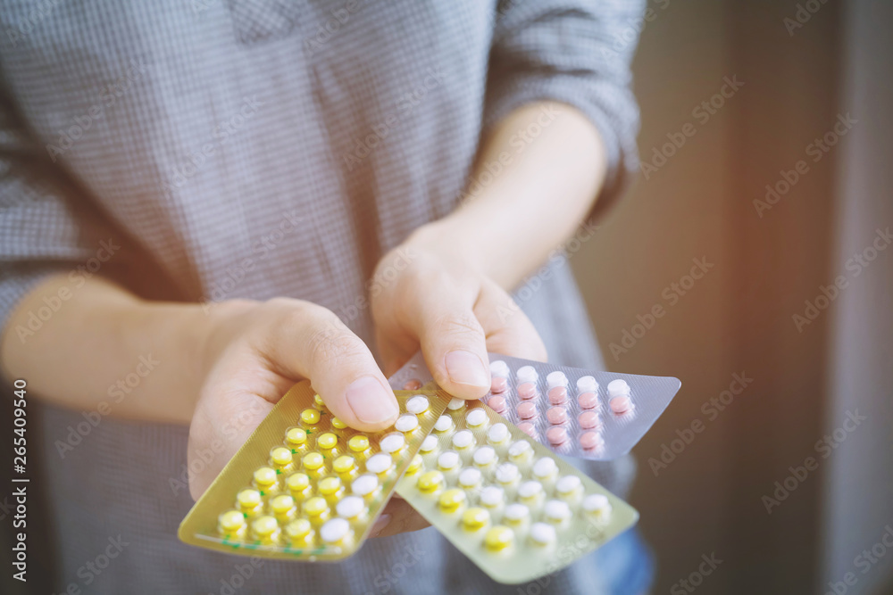 Obraz premium Close up young women hand contraceptive pill on with colorful pills strips. Contraception reduces childbirth and pregnant concept.