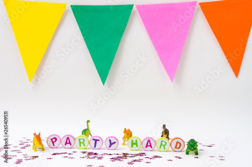 Party hard made from colorful letters, toy little dinosaurs and stars confetti on white background