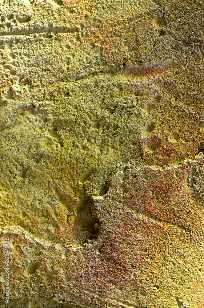 Background texture of yellow with orange stone with cracks, irregularities and divorces. Blur, close-up, top view, plenty of space for text, nobody, vertical. Concept of design and nature.