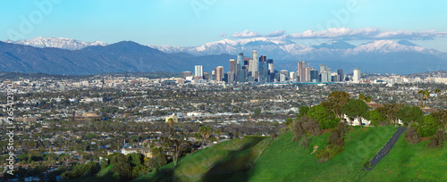 Panoramic view of the city of Los Angeles California with snowy mountain caps showing the end of the drought due to climate change.  The wide view shows Hollywood and Downtown. photo