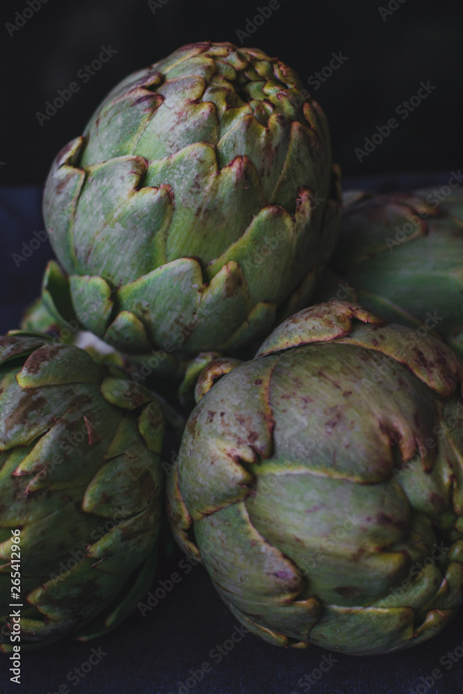 Obraz premium fresh french artichokes at the market. Dark food background