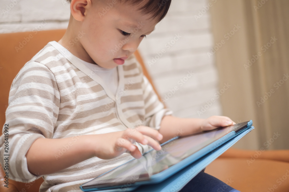 Confused aggressive Asian 2 - 3 years old toddler boy child using tablet pc playing game while waiting for his flight at Airport lounge, Gadget addicted children,Traveling with kid concept Confused aggressive Asian 2 - 3 years old toddler boy child using tablet pc playing game while waiting for his flight at Airport lounge, Gadget addicted children,Traveling with kid concept