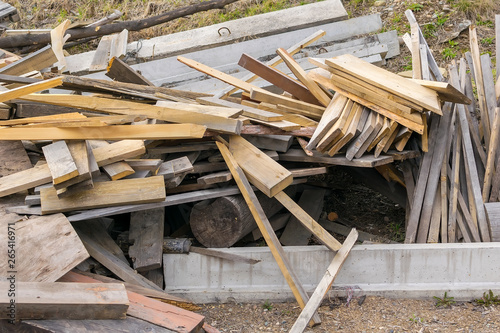 Piled in a pile of debris, pieces of boards, plywood and concrete blocks. Lumber, garbage, firewood