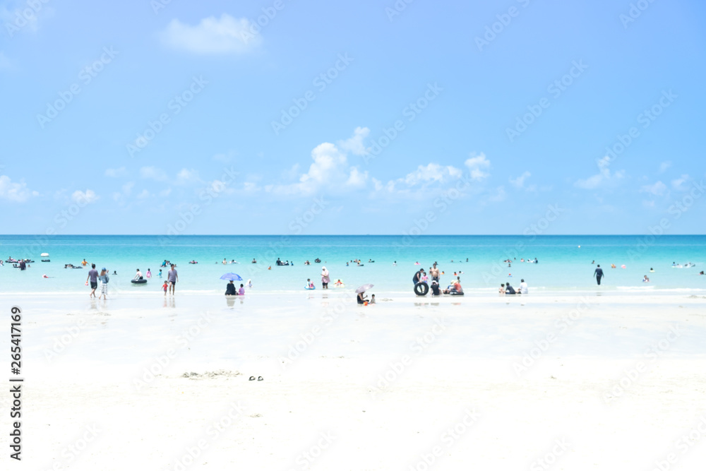 Blur group of people are doing activity on the beach with sand sea and bright sky with sunshine day in vacation and holiday. for background.