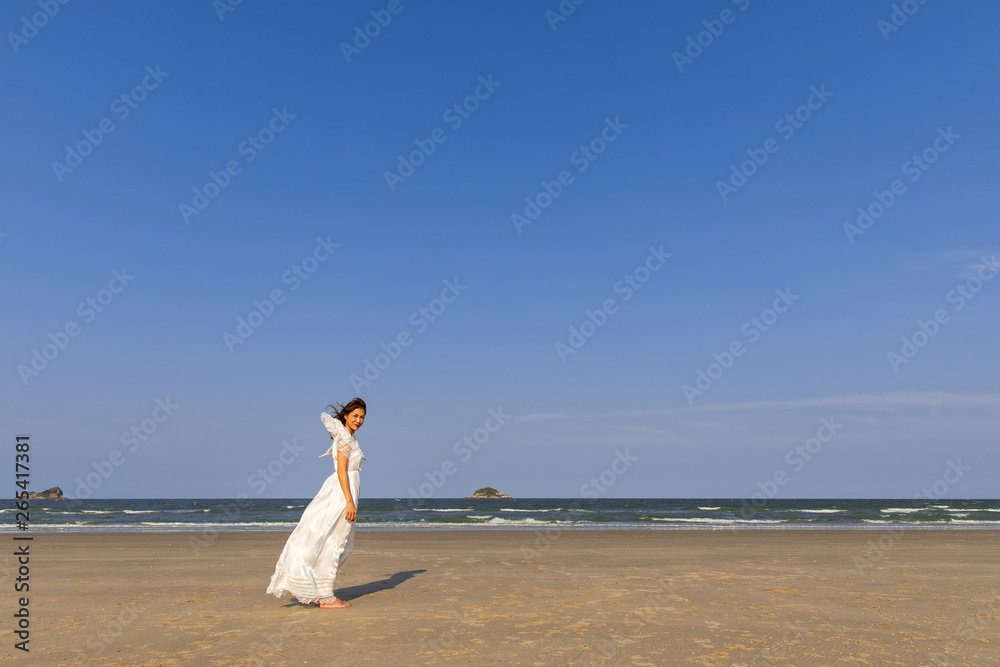 Woman in white dress on beach