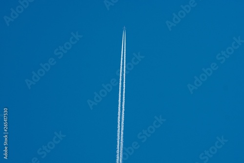 airplane in the sky leaving a contrail  © Gene