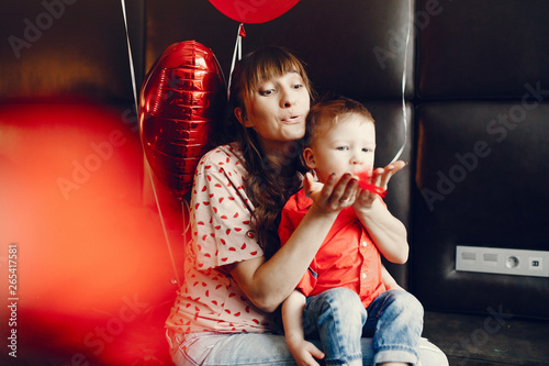 Pregnant woman at home. Mother with son in a bed. Family in a room with decorstions for Valentine's day photo