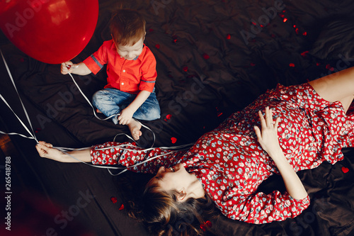 Pregnant woman at home. Mother with son in a bed. Family in a room with decorstions for Valentine's day photo