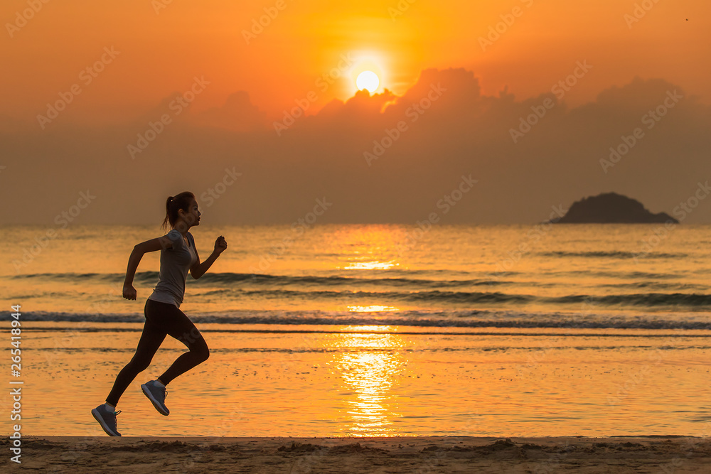 Woman running on beach at sunrise Woman running on beach at sunrise