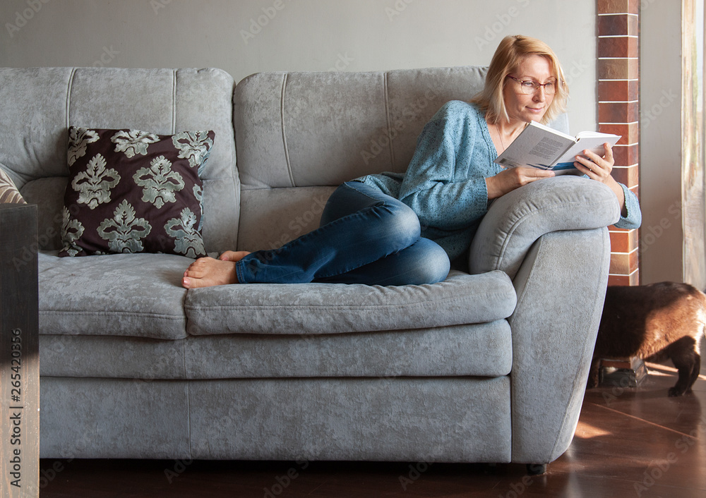 woman reading a book on the couch woman reading a book on the couch