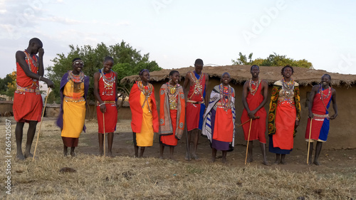 wide view of a group of ten maasai women and men singing photo