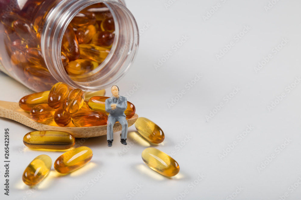 Fish oil capsules in a wooden spoon on white background, omega 3 and vitamin B,C,D healthy diet concept. Fish oil capsules in a wooden spoon on white background, omega 3 and vitamin B,C,D healthy diet concept.
