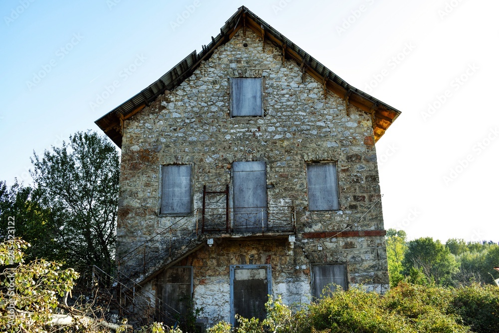 Old abandoned made of rocks  house in village.