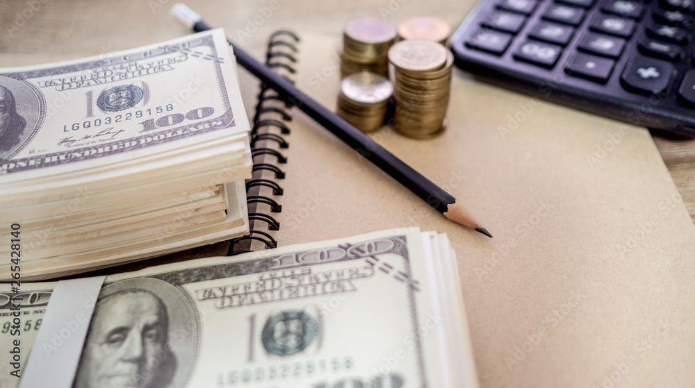Coins and Dollar money, pencil, calculator, brown note placed on a table. (have copy space for text) Coins and Dollar money, pencil, calculator, brown note placed on a table. (have copy space for text)