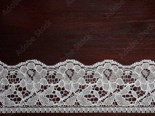 White laces on a brown wooden background horizontally in row