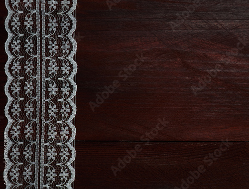 White laces on a brown wooden background vertically