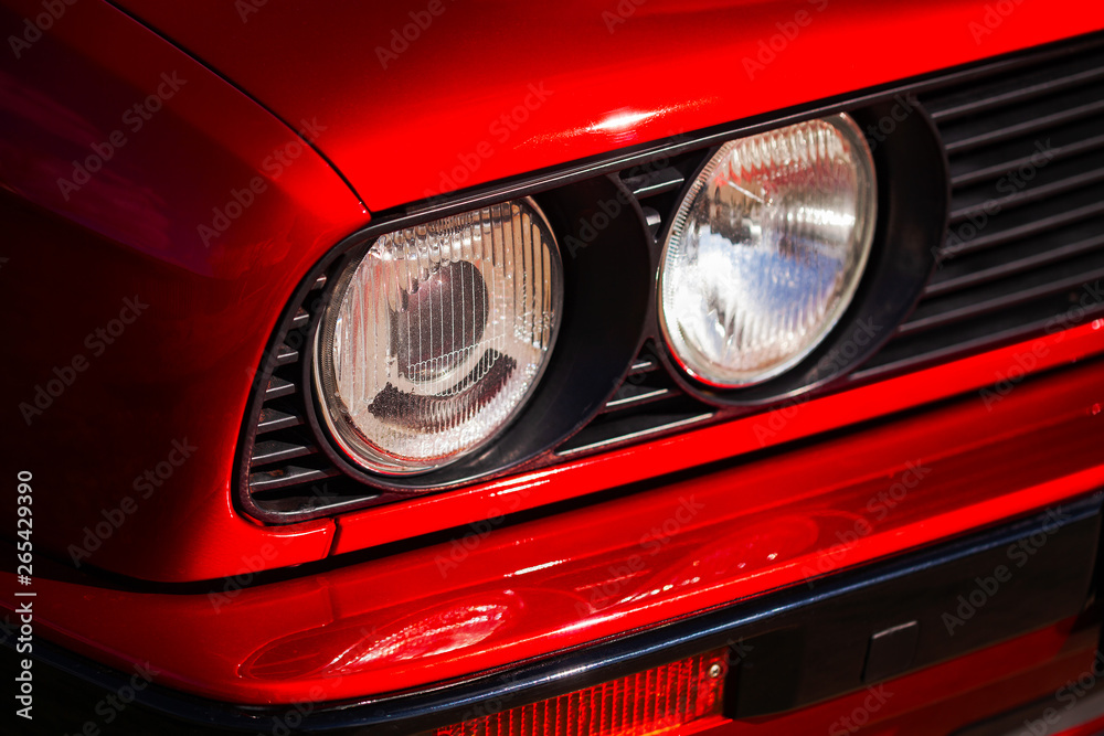 Headlights of a red, old, retro car, closeup