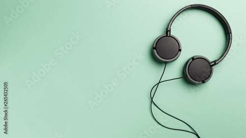 Black headphones on Mint background. Headphones on a pastel background. Flat lay top view copy space. Minimal style with colorful paper backdrop. Music concept. Neo Mint color of the year 2020 photo