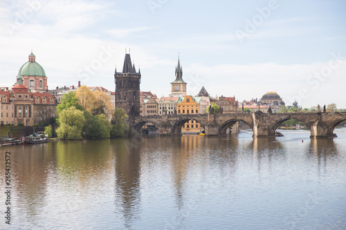 Old Charles bridge and buildings. Vltava river with glare. Travel photo 2019. © ynos