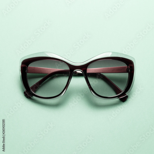 Fashion sunglasses on Mint background. Top view. Flat lay. Minimal style with colorful paper backdrop. Summer is coming concept. Neo Mint color of the year 2020
