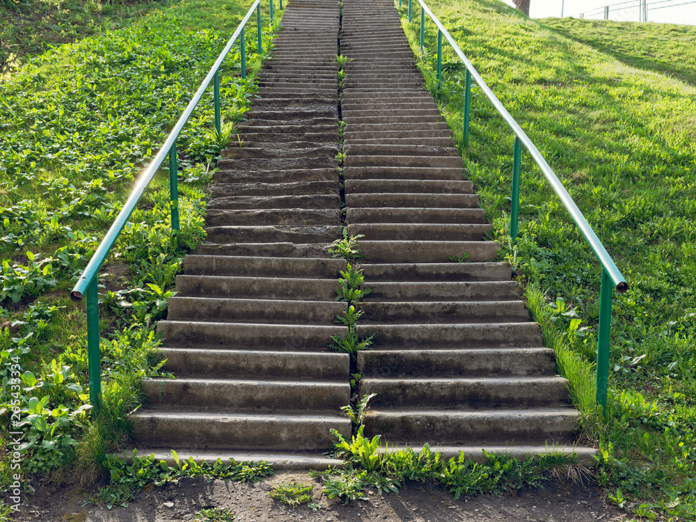 concrete staircase on a steep slope of green grass concrete staircase on a steep slope of green grass