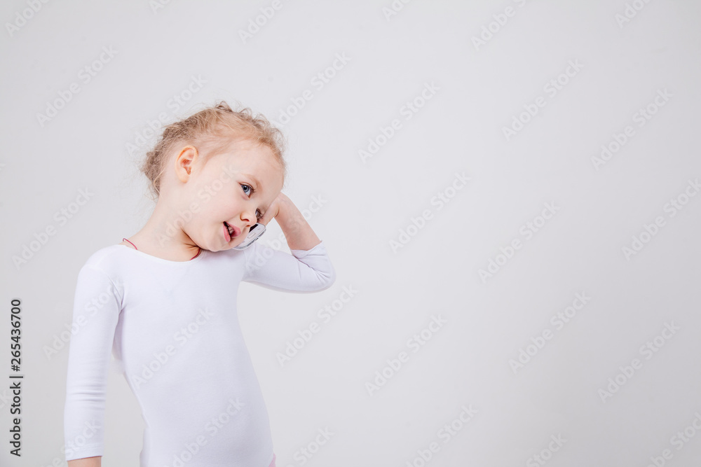 Portrait of the little girl's positive that talking on a cell phone, isolated on white background. Portrait of the little girl's positive that talking on a cell phone, isolated on white background.