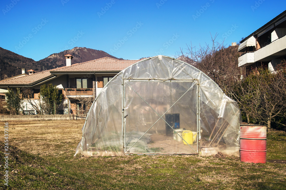 Greenhouse in the garden. Horticulture near the house,availability of fresh vegetables close to home