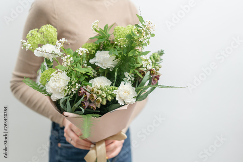Two Beautiful bouquets of mixed flowers in womans hands. the work of the florist at a flower shop. Delicate Pastel color. Fresh cut flower. Green and white color