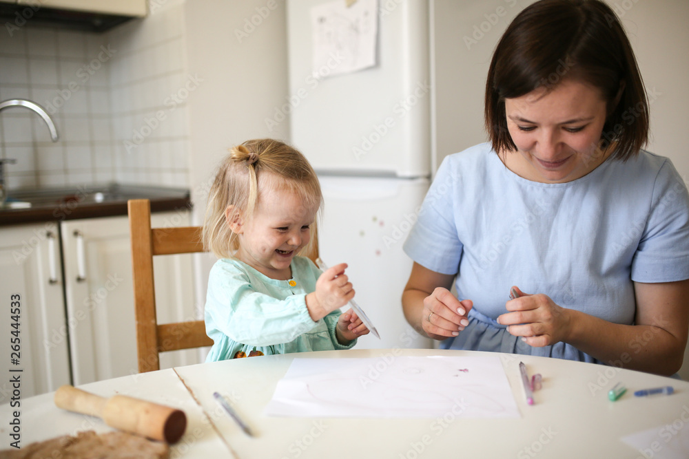 Mom and cute blonde girl in dresses paint together Mom and cute blonde girl in dresses paint together