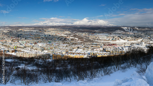 Winter panorama landscape residential buildings of Petropavlovsk-Kamchatsky City, scenery volcanoes of Kamchatka Peninsula: Koryak Volcano, Avacha Volcano, Kozelsky Volcano. Russian Far East, Eurasia.