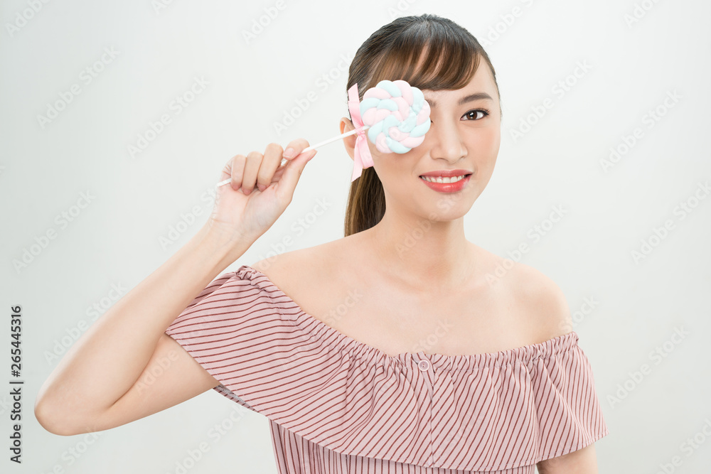 Short hair asian young beautiful woman smiling, covering her eye with lollipop. isolated over white background. Short hair asian young beautiful woman smiling, covering her eye with lollipop. isolated over white background.