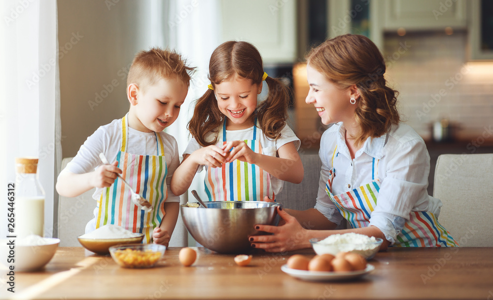 Fototapeta premium happy family in kitchen. mother and children preparing dough, bake cookies.