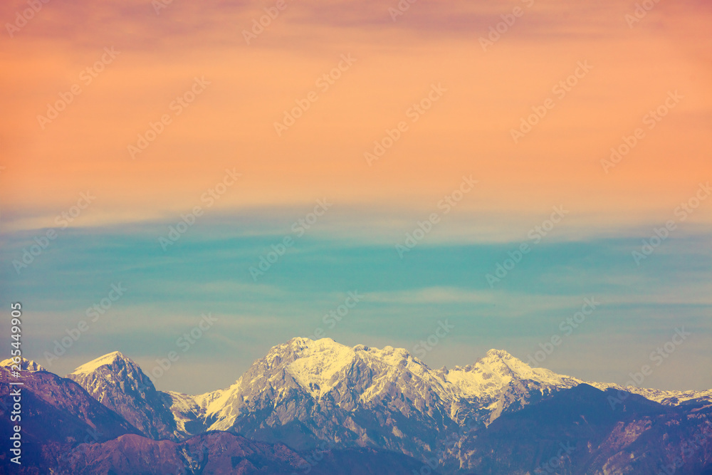 Mountain landscape in the evening. Mountain range covered with snow against a gradient sunset sky