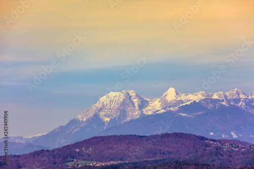 Mountain landscape in the evening. Mountain range covered with snow against a gradient sunset sky