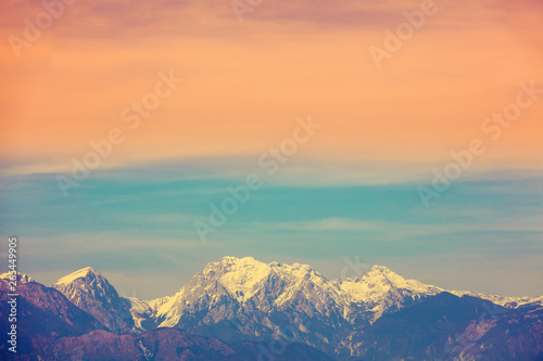 Mountain landscape in the evening. Mountain range covered with snow against a gradient sunset sky © vvvita