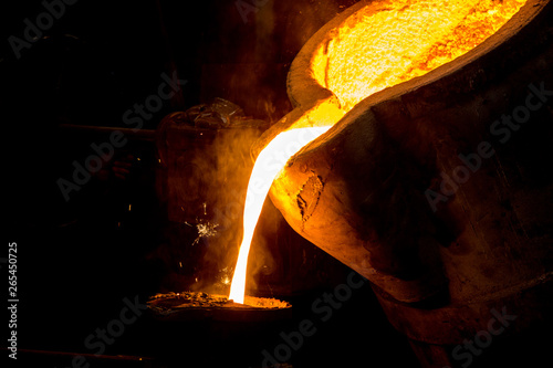 metal casting process with red high temperature fire in metal part factory photo