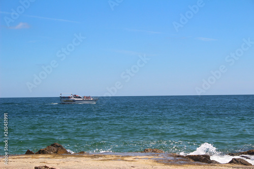 Fototapeta Naklejka Na Ścianę i Meble -  The beautiful sea floats a white yacht along the rocky shore. Beautiful Wallpapers for your computer.