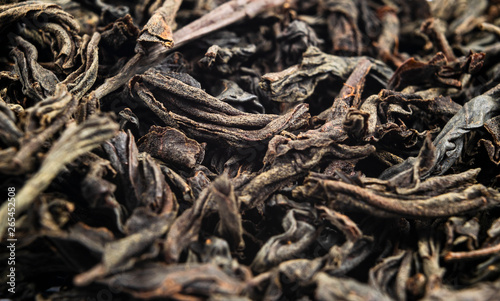 Macro shot of a high quality black tea. Black tea background close up. Leaf closeup. Background of dried tea leaves of dark color. Macro photo. Pile of black tea leaves.