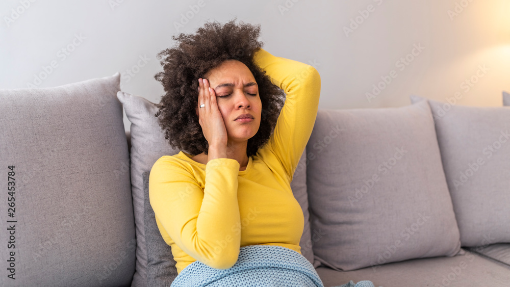 Young woman suffering from strong headache or migraine sitting at home, millennial guy feeling intoxication and pain