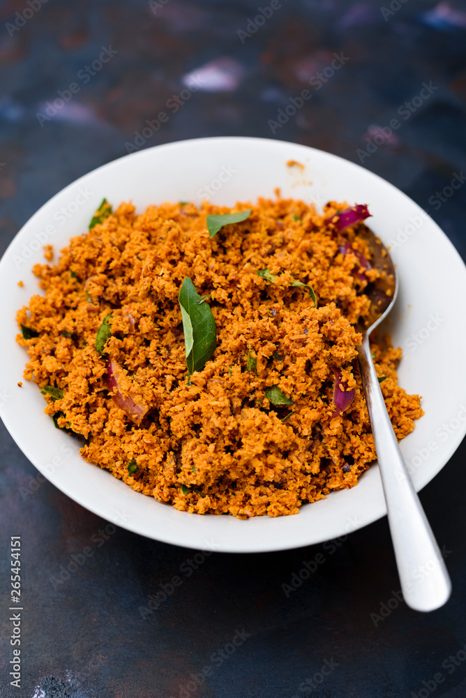 Coconut sambal, a Srilankan/ Indian spicy dish, in a bowl on a textured background. Coconut sambal, a Srilankan/ Indian spicy dish, in a bowl on a textured background.