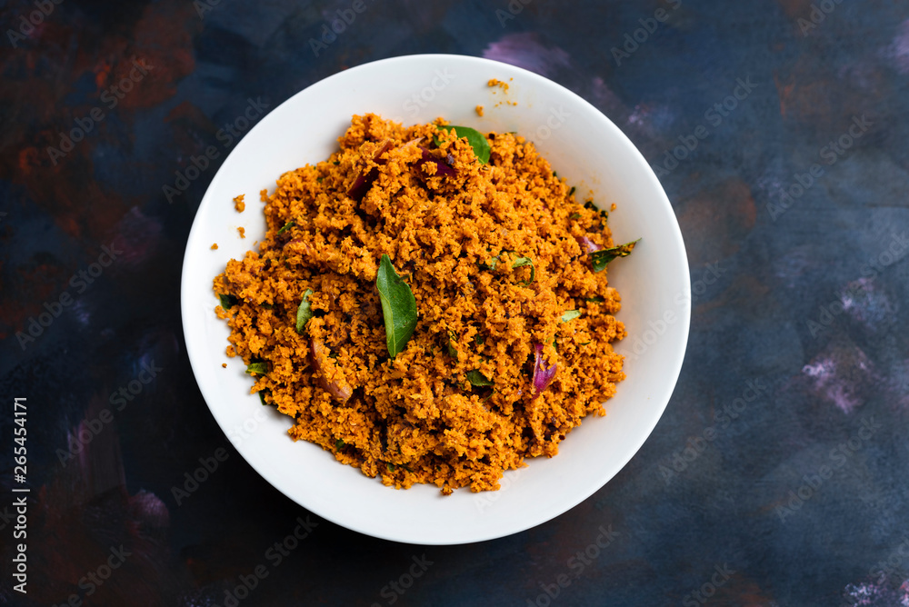 Coconut sambal, a Srilankan/ Indian spicy dish, in a bowl on a textured background. Coconut sambal, a Srilankan/ Indian spicy dish, in a bowl on a textured background.