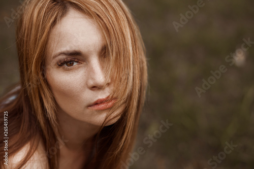 Portrait of a girl with long hair, looking at the camera. copy space