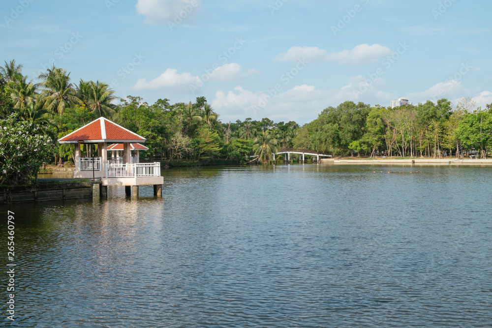 Landscape view of a lake and waterfront pavilions surrounded by lush green forest in Sri Nakhon Khuan Khan Park and botanical garden. Bang Krachao, Samut Prakan, Thailand.