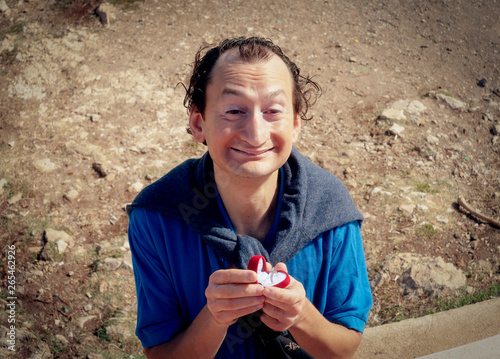 Photography A funny ugly man making a marriage proposal by offering a wedding ring