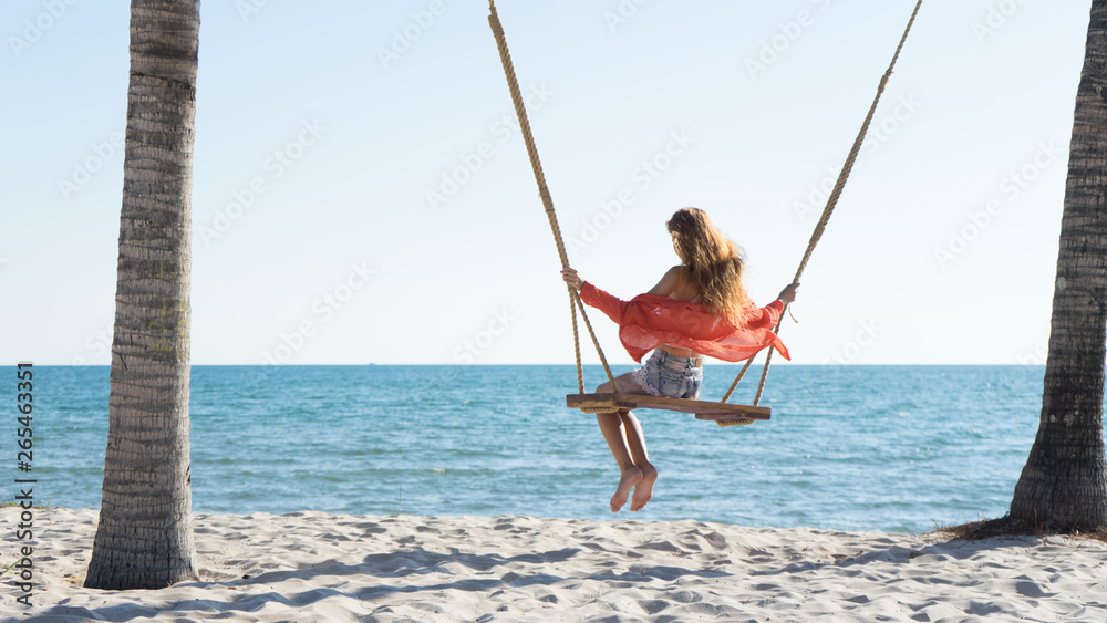 Vacation concept. Young woman swing on a beach swing. Happy traveller women on the Phu Quoc beach