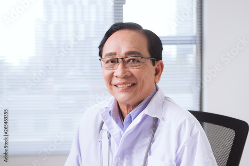 Portrait of senior doctor standing in medical office