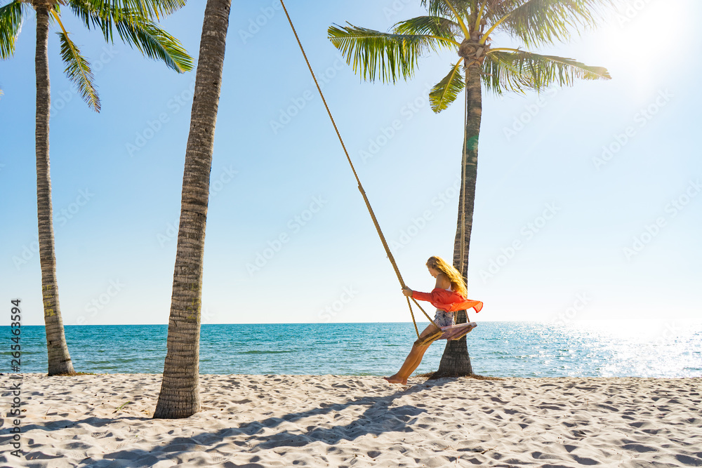 Vacation concept. Young woman swing on a beach swing. Happy traveller women on the Phu Quoc beach Vacation concept. Young woman swing on a beach swing. Happy traveller women on the Phu Quoc beach